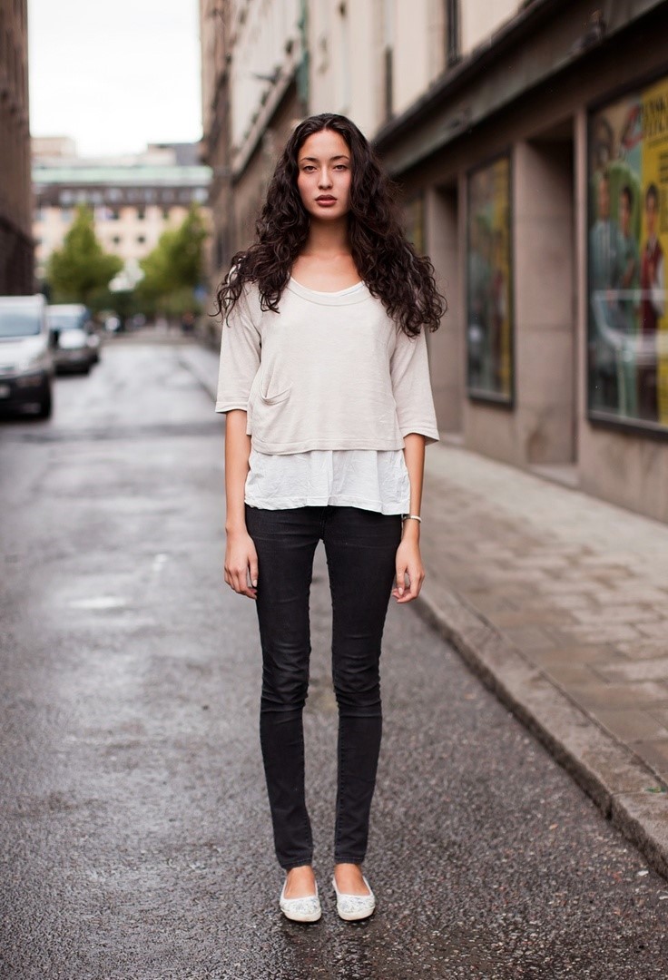 The model in simple tee, skinny jeans and ballet flats.