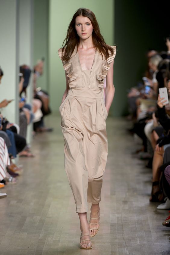 The model in a jumpsuit with pleated ruffle detailing.