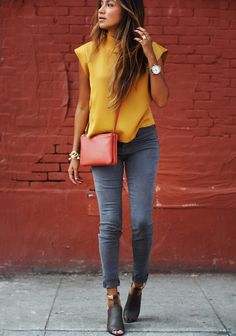 Mustard colored shirt paired with dark grey jeans and black heels 